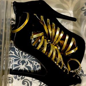 Black 6in high heels with gold metallic straps. Zipper back. Suede like size 10